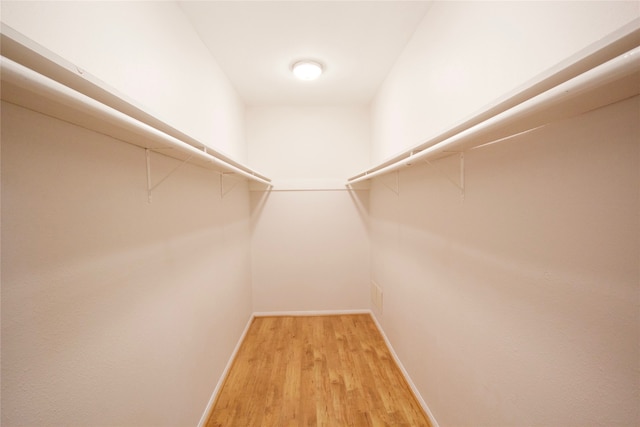 spacious closet with hardwood / wood-style flooring