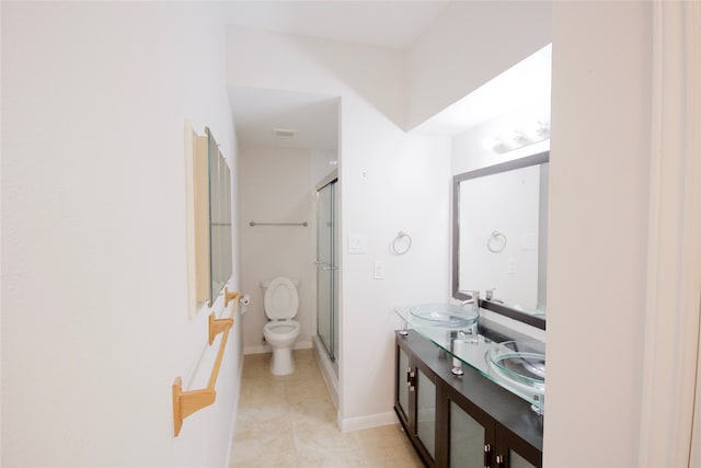 bathroom featuring a shower with door, vanity, toilet, and tile patterned floors