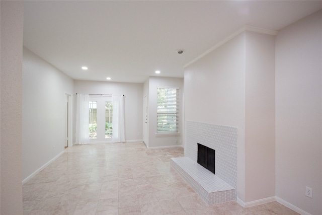 unfurnished living room featuring ornamental molding and a tile fireplace