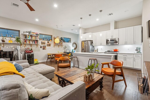 living room featuring ceiling fan, dark wood-type flooring, and wine cooler