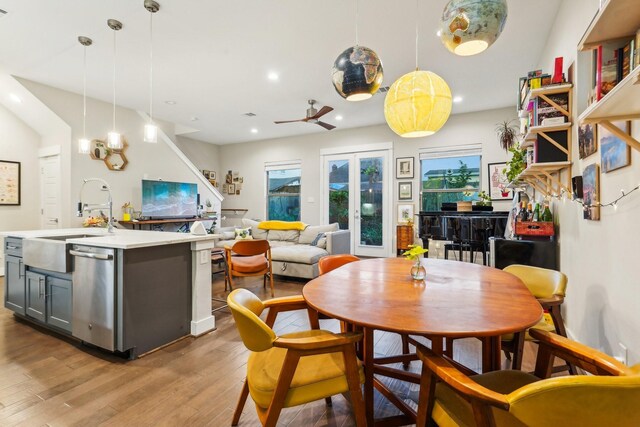 dining space with sink, light wood-type flooring, ceiling fan, and french doors