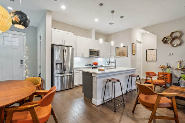 kitchen with white cabinetry, sink, pendant lighting, an island with sink, and stainless steel appliances