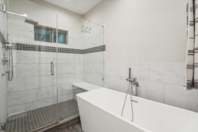 bathroom with tile walls and plus walk in shower