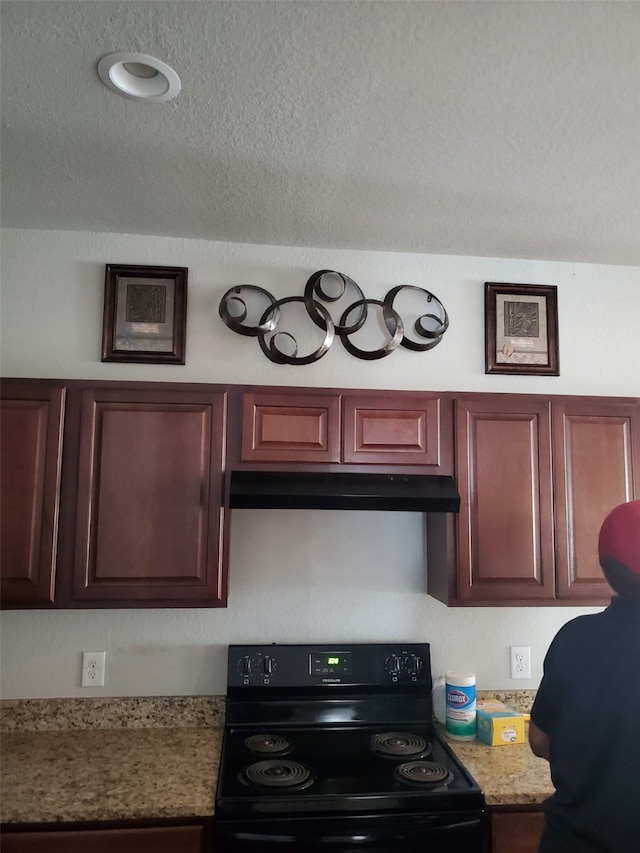 kitchen featuring light stone countertops, black / electric stove, and a textured ceiling