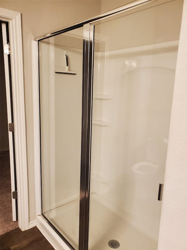 bathroom featuring hardwood / wood-style floors and a shower with shower door