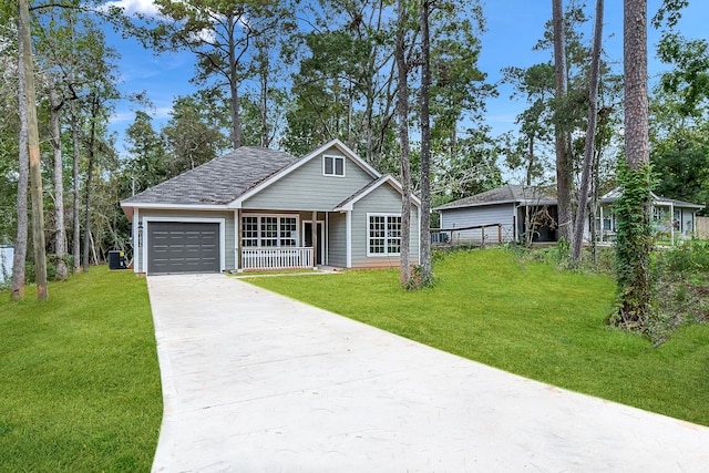 view of front of home with a front lawn, central AC unit, covered porch, and a garage