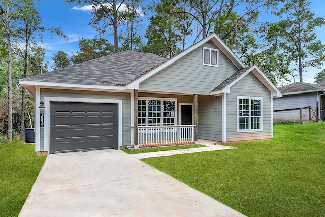 view of front of house featuring a garage, central AC, a front lawn, and covered porch