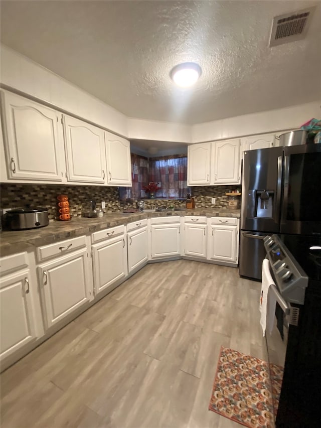 kitchen with decorative backsplash, light hardwood / wood-style flooring, stainless steel refrigerator with ice dispenser, white electric range oven, and white cabinets