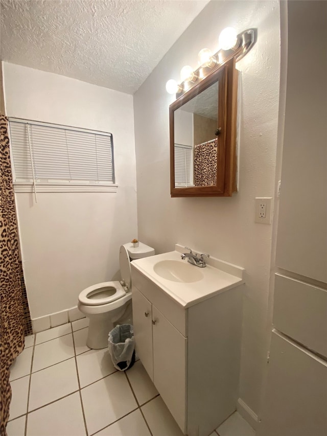 bathroom with a textured ceiling, walk in shower, toilet, vanity, and tile patterned floors