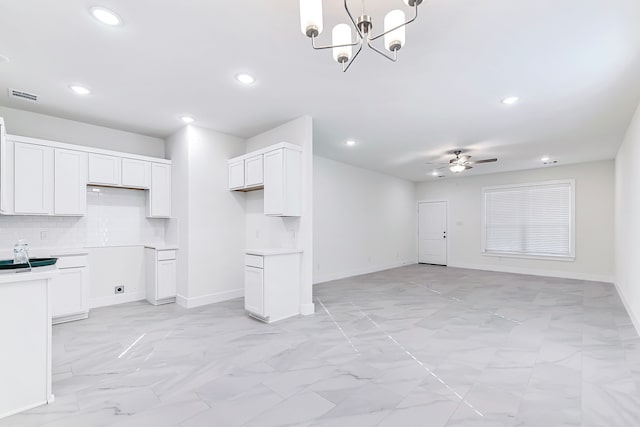 kitchen featuring decorative light fixtures, white cabinetry, and ceiling fan with notable chandelier