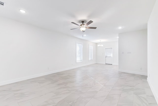 unfurnished room with ceiling fan with notable chandelier