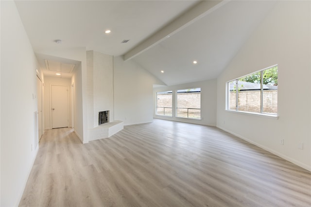 unfurnished living room with beamed ceiling, high vaulted ceiling, light wood-type flooring, and a brick fireplace