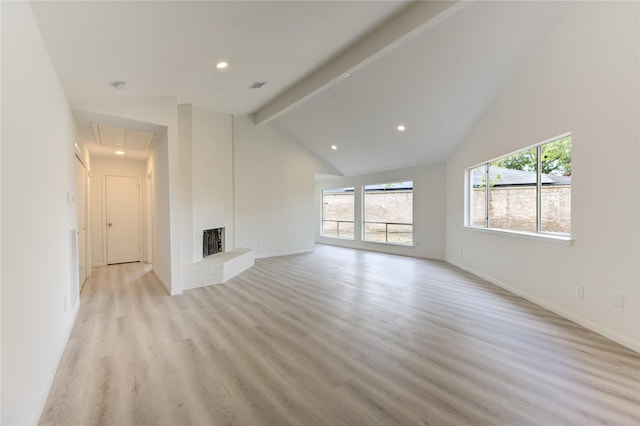 unfurnished living room featuring beamed ceiling, a large fireplace, high vaulted ceiling, and light hardwood / wood-style floors