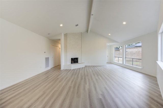 unfurnished living room with beamed ceiling, high vaulted ceiling, a fireplace, and light hardwood / wood-style floors