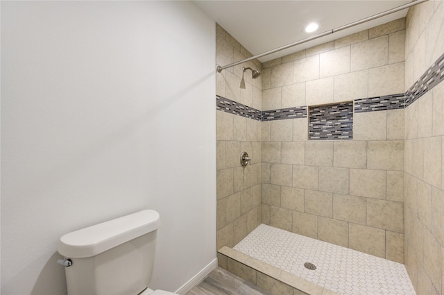 bathroom with toilet and a tile shower