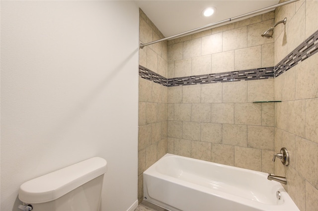 bathroom featuring toilet and tiled shower / bath