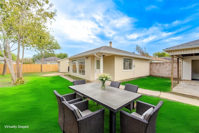 back of house featuring a patio and a lawn