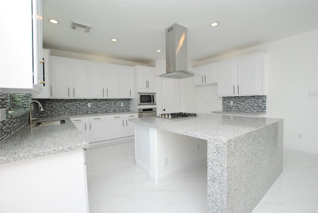 kitchen with appliances with stainless steel finishes, white cabinets, a center island, and exhaust hood