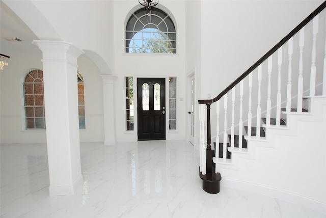 foyer with a towering ceiling and ornate columns