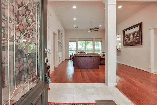 interior space featuring crown molding, wood-type flooring, ornate columns, and ceiling fan