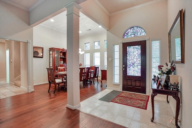 foyer entrance with decorative columns, light hardwood / wood-style flooring, and a wealth of natural light