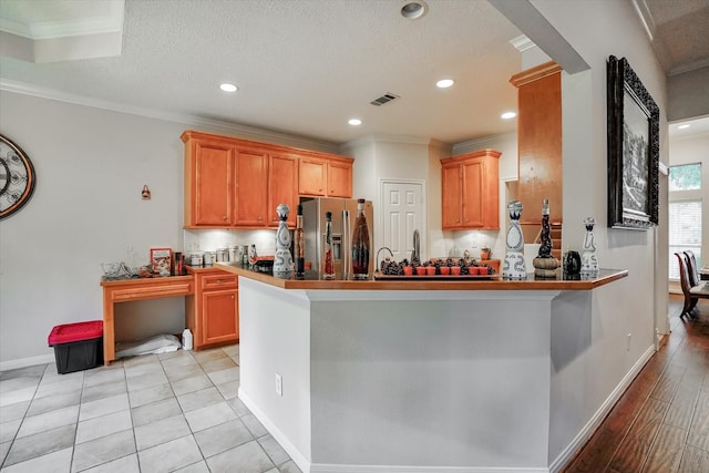 kitchen featuring crown molding, kitchen peninsula, and stainless steel refrigerator with ice dispenser