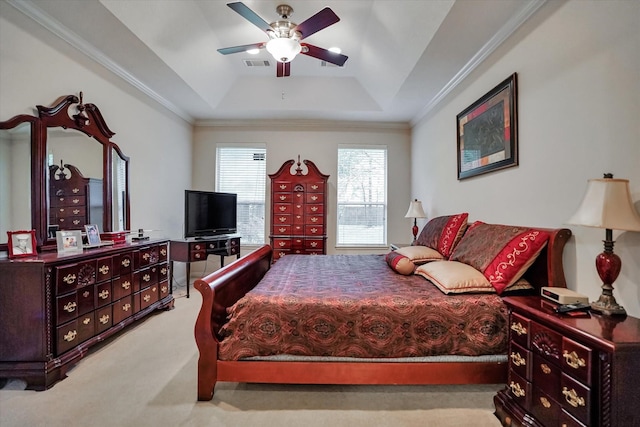 bedroom featuring crown molding, a tray ceiling, light colored carpet, and ceiling fan