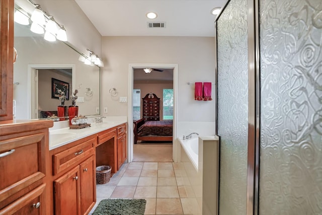 15420 Winterhaven Dr, Tomball, TX 77377 - ensuite bathroom featuring tile patterned floors, double vanity, a bath, a ceiling fan, and recessed lighting