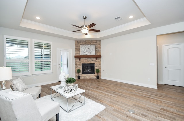 living room featuring a tray ceiling, light hardwood / wood-style floors, and ceiling fan