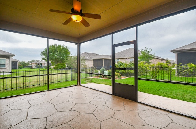 unfurnished sunroom featuring ceiling fan