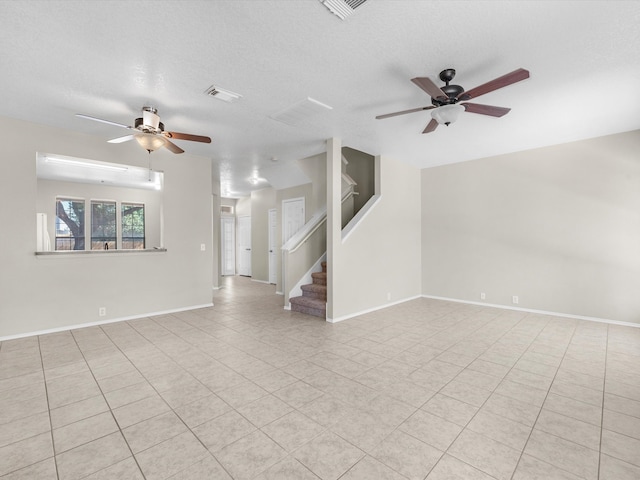 unfurnished living room with ceiling fan, a textured ceiling, and light tile patterned flooring