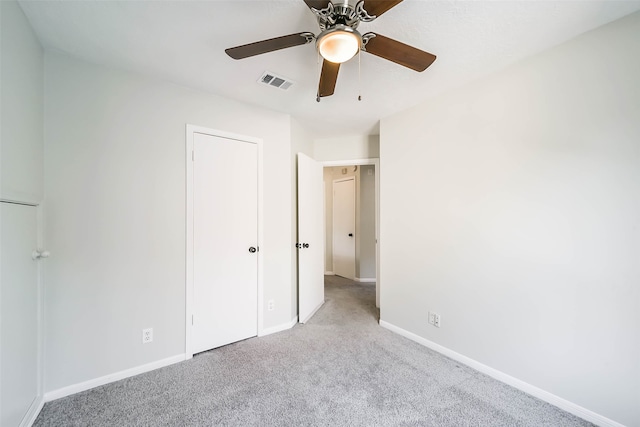 unfurnished bedroom featuring light carpet and ceiling fan