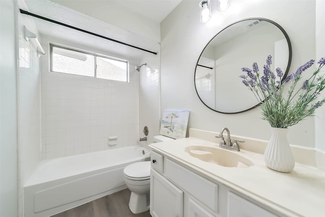 full bathroom featuring vanity, toilet, hardwood / wood-style floors, and tiled shower / bath