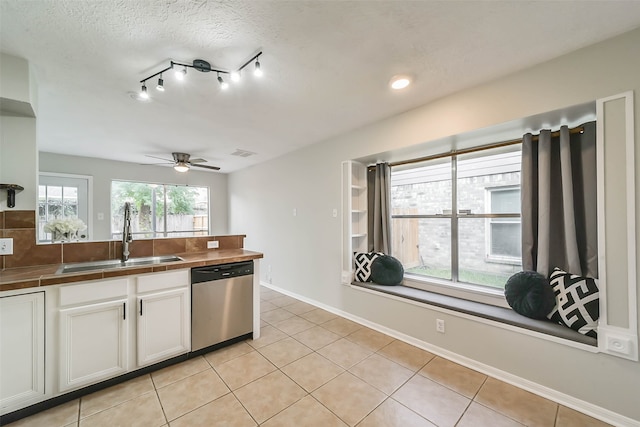 kitchen featuring white cabinets, tile countertops, a textured ceiling, dishwasher, and sink