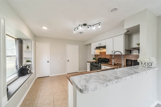 kitchen with black appliances, light tile patterned flooring, backsplash, kitchen peninsula, and white cabinetry