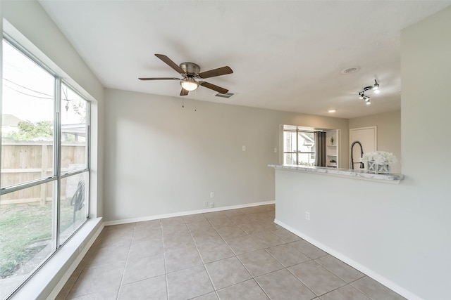 tiled spare room with ceiling fan