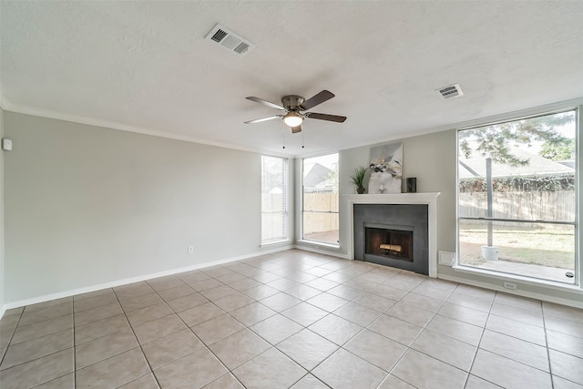 unfurnished living room with ceiling fan, a textured ceiling, a healthy amount of sunlight, and light tile patterned floors