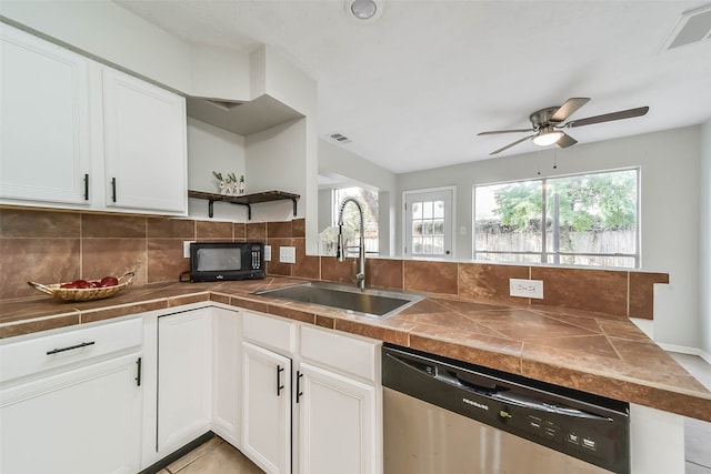 kitchen featuring stainless steel dishwasher, sink, white cabinetry, and tile countertops