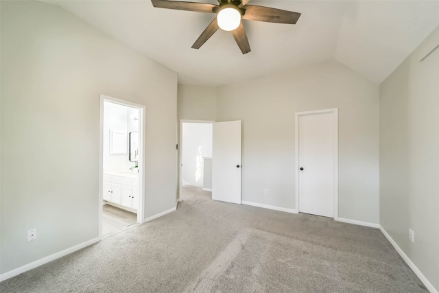 unfurnished bedroom with lofted ceiling, ceiling fan, ensuite bathroom, and light colored carpet