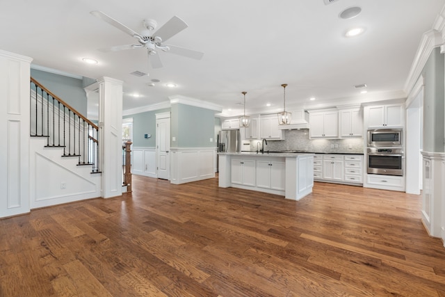 kitchen with dark wood-type flooring, appliances with stainless steel finishes, hanging light fixtures, and white cabinets