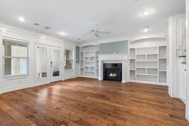 unfurnished living room featuring ornamental molding, dark wood-type flooring, and ceiling fan