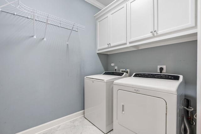 laundry area featuring cabinets, ornamental molding, and washing machine and clothes dryer