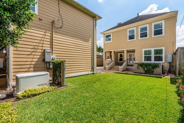 rear view of property featuring a lawn