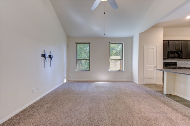 unfurnished living room with dark colored carpet and ceiling fan