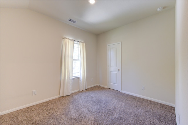 carpeted empty room with vaulted ceiling