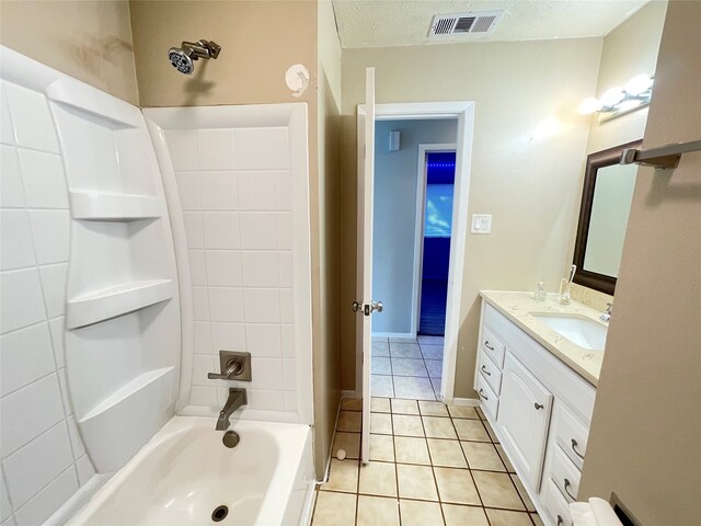 bathroom featuring vanity, tiled shower / bath combo, a textured ceiling, and tile patterned flooring