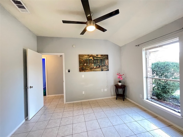 unfurnished room with lofted ceiling, light tile patterned flooring, a healthy amount of sunlight, and ceiling fan