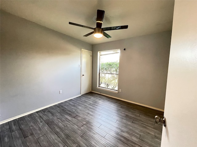 spare room with dark hardwood / wood-style floors and ceiling fan