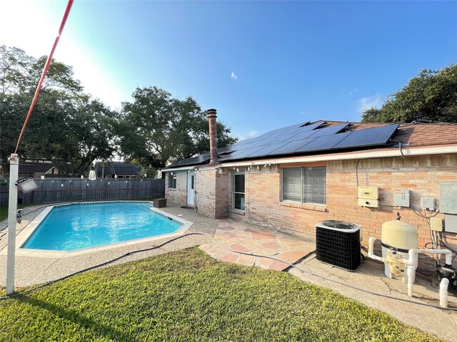 view of swimming pool with central air condition unit, a patio, and a lawn