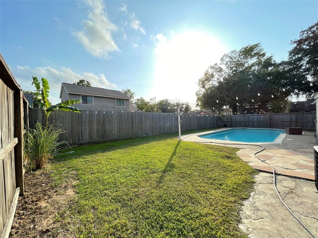 view of yard with a fenced in pool and a patio area